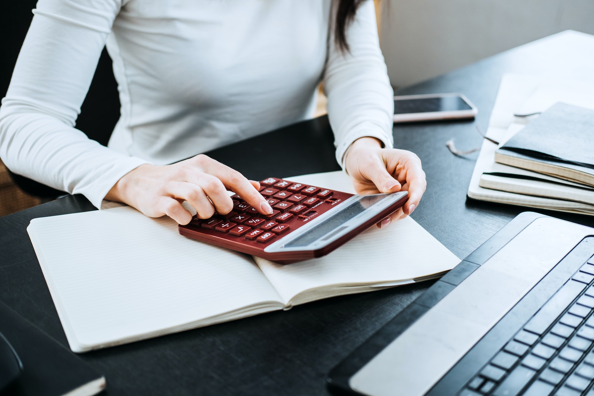 Formules de comptabilité équations pour les comptables. Femme comptable travaillant avec une calculatrice et un ordinateur portable.
