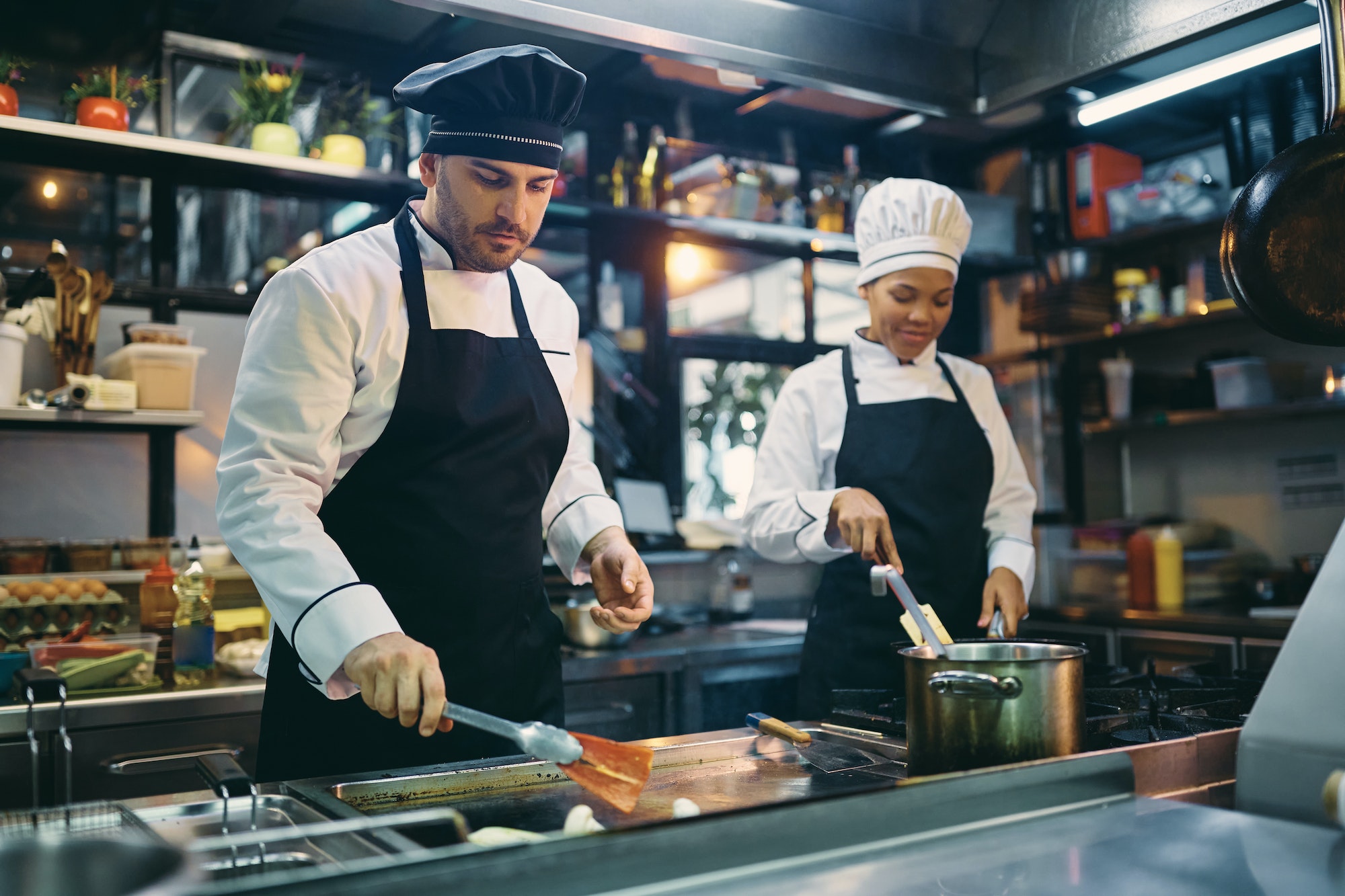 Deux cuisiniers professionnels travaillant dans la cuisine d'un restaurant.