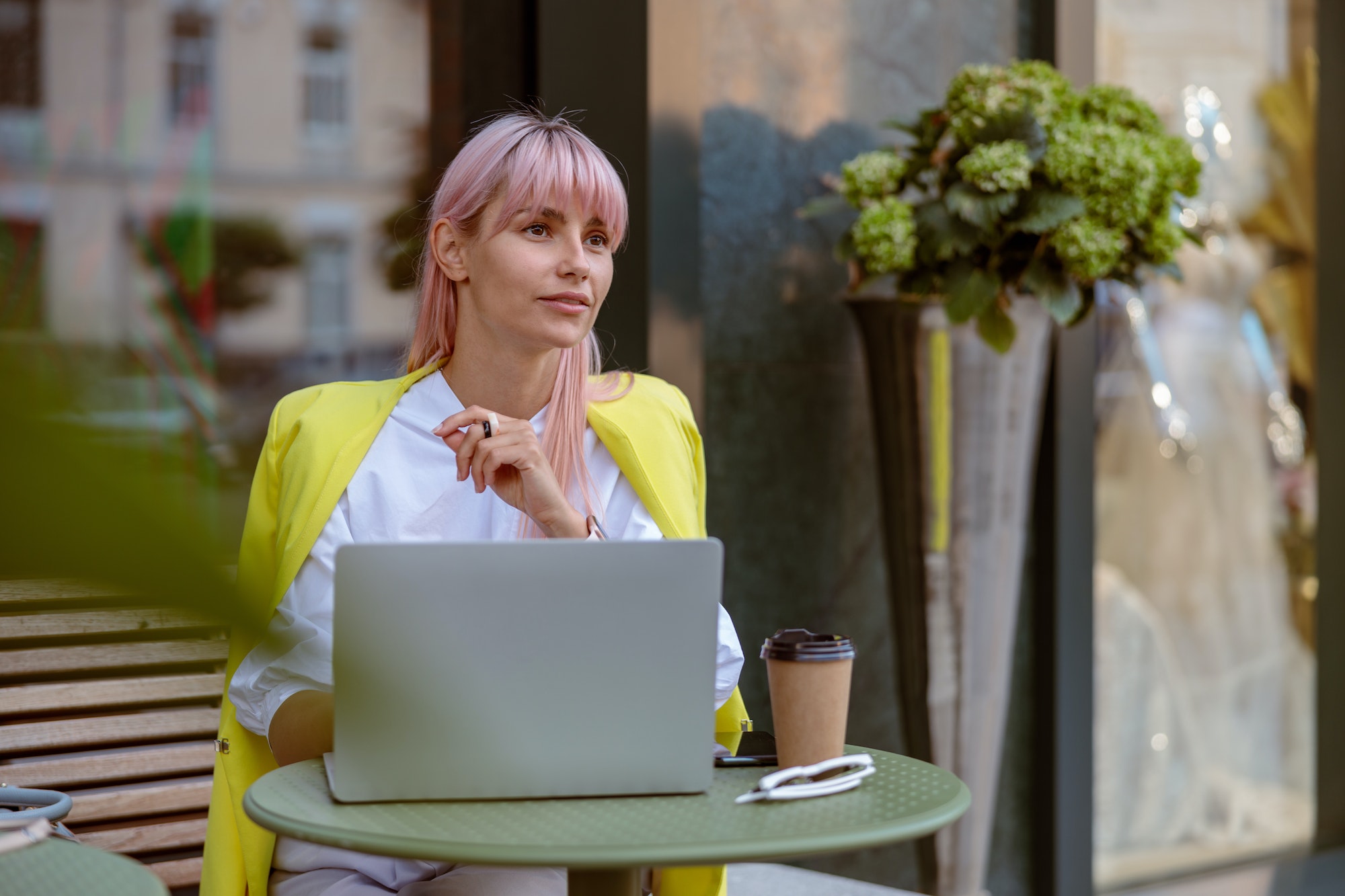 Jeune femme utilisant un ordinateur portable dans un café en plein air