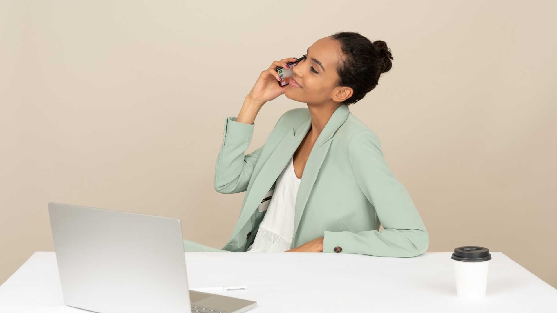 Femme devant son bureau au téléphone
