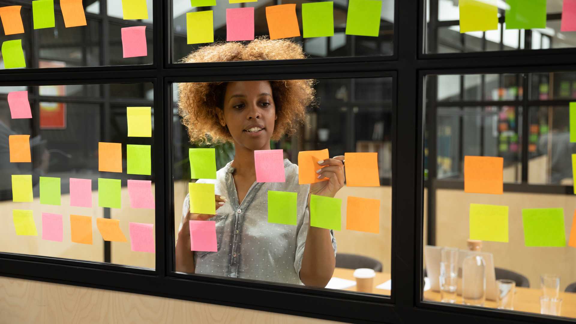 Responsable de projets culturels entrain d'écrire sur des post-it