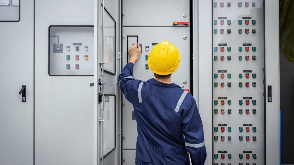 Technicien d’exploitation Energie devant un tableau disjoncteur 